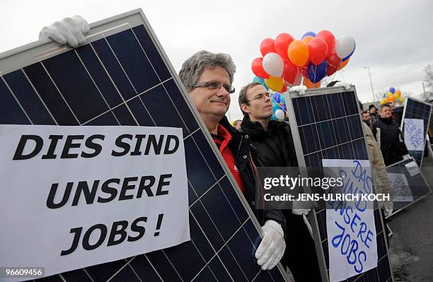 Employees of various solar companies demonstrate with placards reading "These are our jobs" in Erfurt, eastern Germany on February 4, 2010 against...
