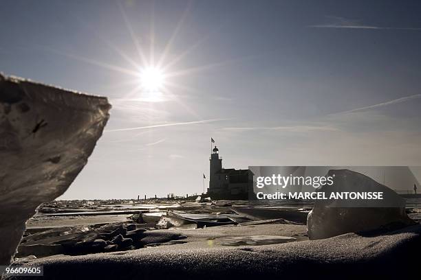 The lighthouse 'het Paard' on the former island of Marken on the IJsselmeer peninsula is surrounded on February 12, by drift-ice. AFP PHOTO / ANP...
