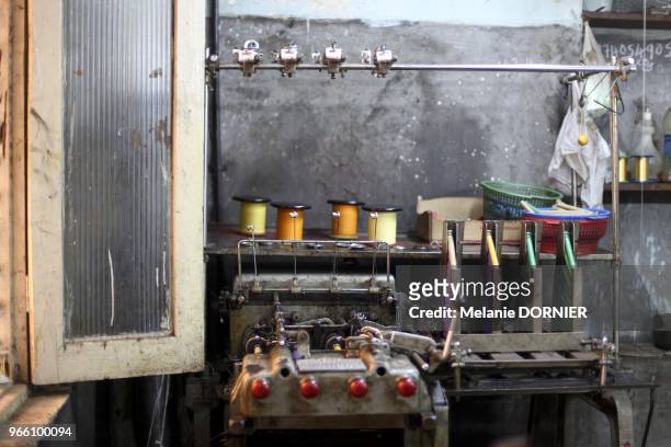 Dans un atelier de Bangalore, une machine electrique qui sert a embobiner le fils de soie aux navettes des metiers a tisser.