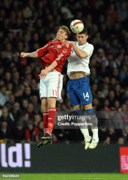 Nicklas Bendtner of Denmark and Gary Cahill of England go for a high ball during the international friendly match between Denmark and England at...