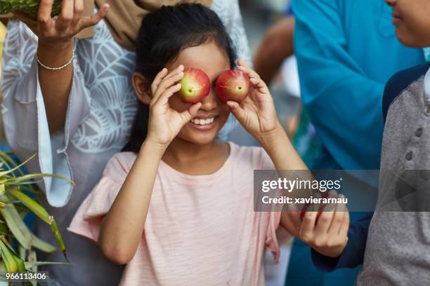 girl covering eyes with water apples in market - water apples stock pictures, royalty-free photos & images