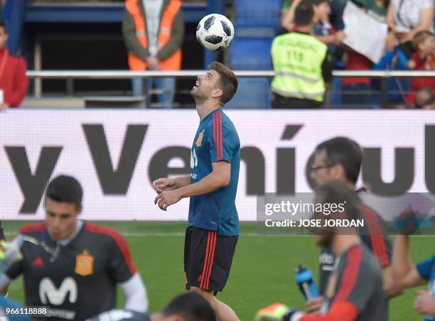 Spain's defender Gerard Pique heads a ball during a training session of Spain's national football team at La Ceramica stadium in Vila-real, on June...