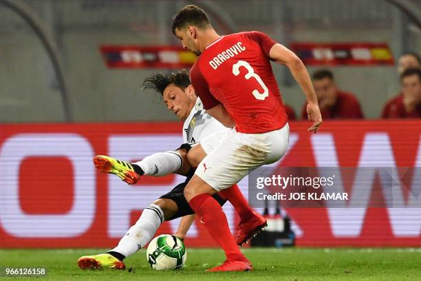 Germany's midfielder Mesut Ozil and Austria's defender Aleksandar Dragovic vie for the ball during the international friendly footbal match Austria v...