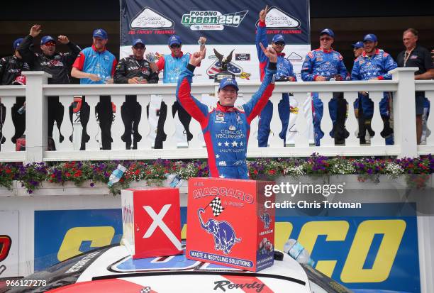 Kyle Busch, driver of the Comcast Salute to Service/Juniper Toyota, celebrates in Victory Lane after winning the NASCAR Xfinity Series Pocono Green...