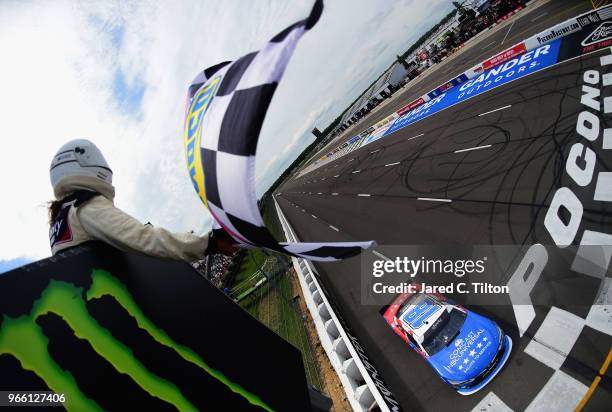 Kyle Busch, driver of the Comcast Salute to Service/Juniper Toyota, takes the checkered flag to win the NASCAR Xfinity Series Pocono Green 250...
