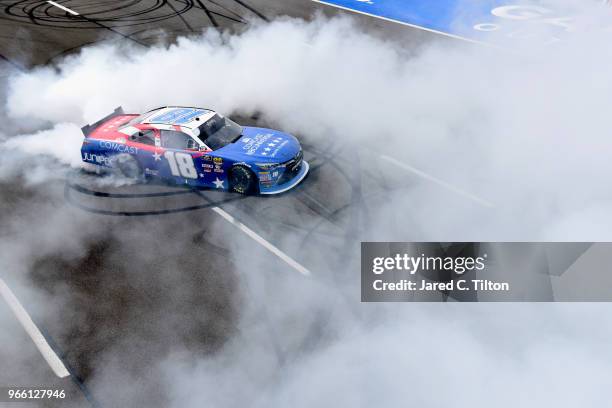 Kyle Busch, driver of the Comcast Salute to Service/Juniper Toyota, celebrates with a burnout after winning the NASCAR Xfinity Series Pocono Green...