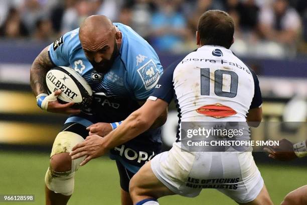 Montpellier's Georgian prop Mikheil Nariashvili runs to evade Castres' Argentinian fly-half Benjamin Urdapilleta during the French Top 14 final rugby...