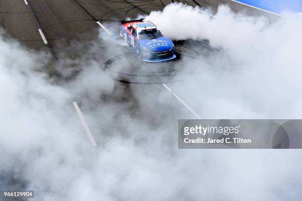 Kyle Busch, driver of the Comcast Salute to Service/Juniper Toyota, celebrates with a burnout after winning the NASCAR Xfinity Series Pocono Green...