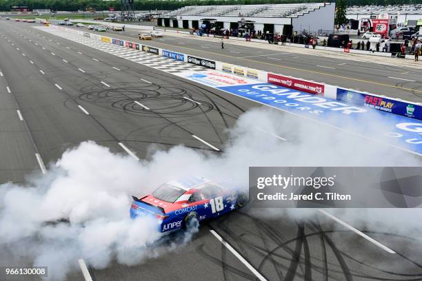 Kyle Busch, driver of the Comcast Salute to Service/Juniper Toyota, celebrates with a burnout after winning the NASCAR Xfinity Series Pocono Green...