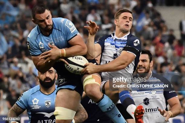 Castres' French scrum-half Rory Kockott and Montpellier's French number 8 Louis Picamoles jump for the ball during the French Top 14 final rugby...