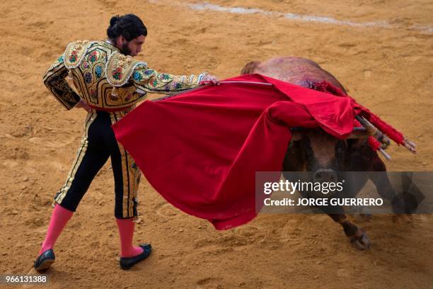 Spanish matador Morante de la Puebla performs a pass with muleta on a bull during the Corpus bullfighting festival at the Granada bullring on June 2,...