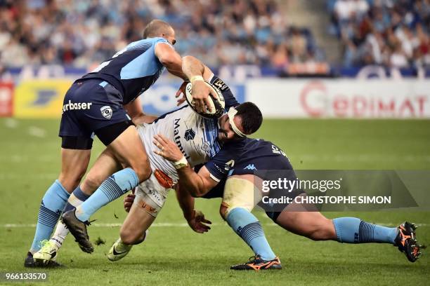 Castres' French centre Thomas Combezou is is tackled by Montpellier's South African scrum-half Ruan Pienaar during the French Top 14 final rugby...