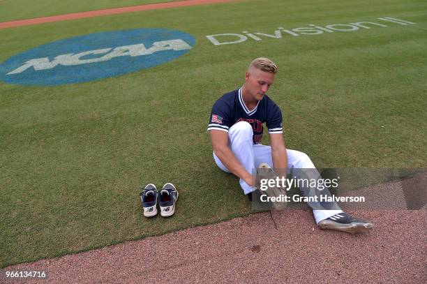 Austin Collins of the Columbus State Cougars laces up his cleats during the Division II Men's Baseball Championship against the Augustana Vikings...