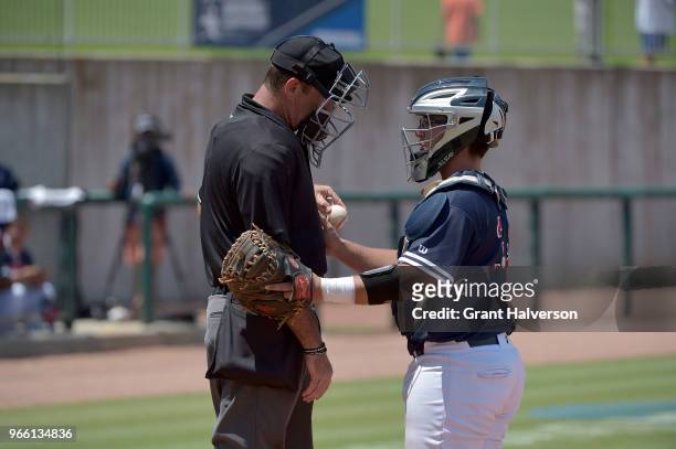 Robert Brooks of the Columbus State Cougars checks on home plate umpire Patrick Griffin after Griffin had a four ball hit his facemark during the...