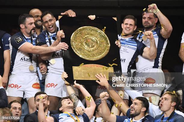Castres' players celebrate with the bouclier de Brennus trophy after winning the French Top 14 final rugby union match between Montpellier and...