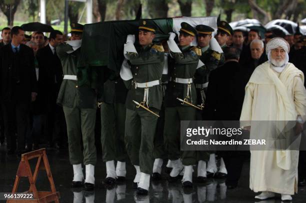 Military officers carry the wooden coffin of Algeria's first post-independence president Ahmed Ben Bella during his national funerals on April 13,...