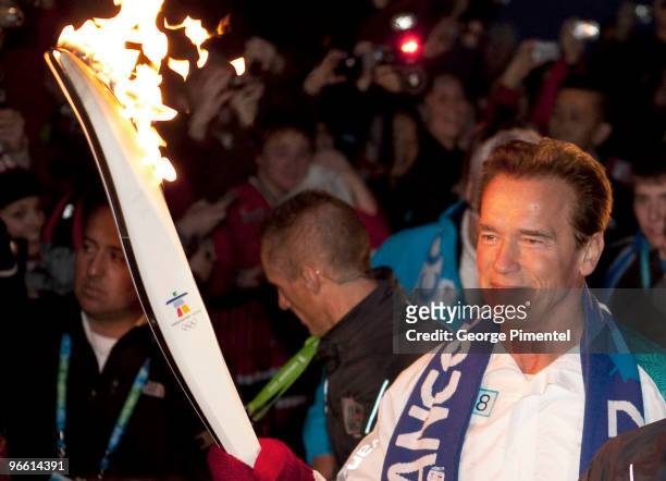 California Governor Arnold Schwarzenegger carries the Olympic Flame during the Vancouver 2010 Olympic Torch Relay ahead of the Vancouver 2010 Winter...