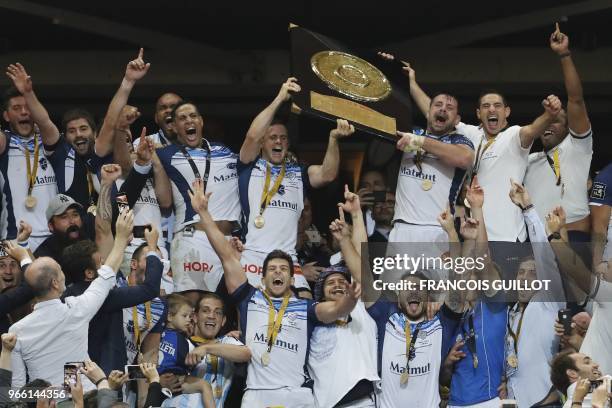 Castres' players celebrate with the bouclier de Brennus trophy after winning the French Top 14 final rugby union match between Montpellier and...