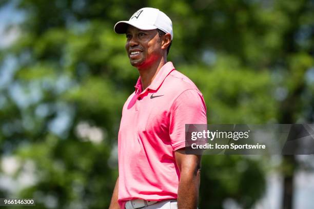 Tiger Woods smiles at the cheering crowd as he approaches the eighteenth tee during the third round of the Memorial Tournament at Muirfield Village...