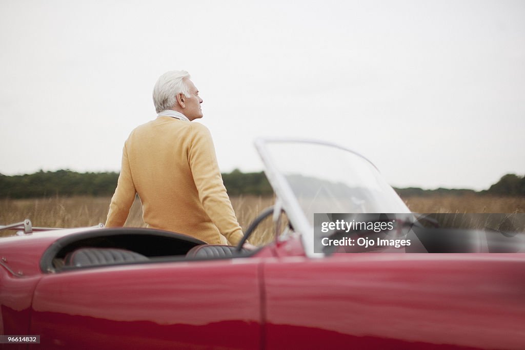 Man leaning on convertible car