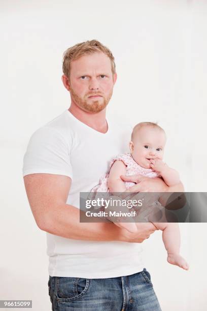 man holding baby, looking grumpy - baby frowning stock pictures, royalty-free photos & images