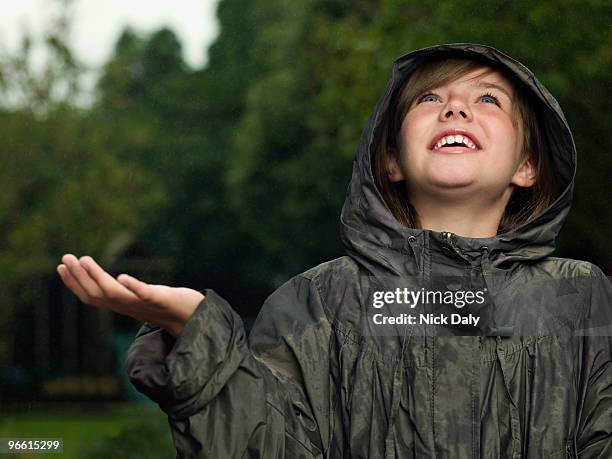 girl holds hand out to catch rain - caught in rain stock pictures, royalty-free photos & images