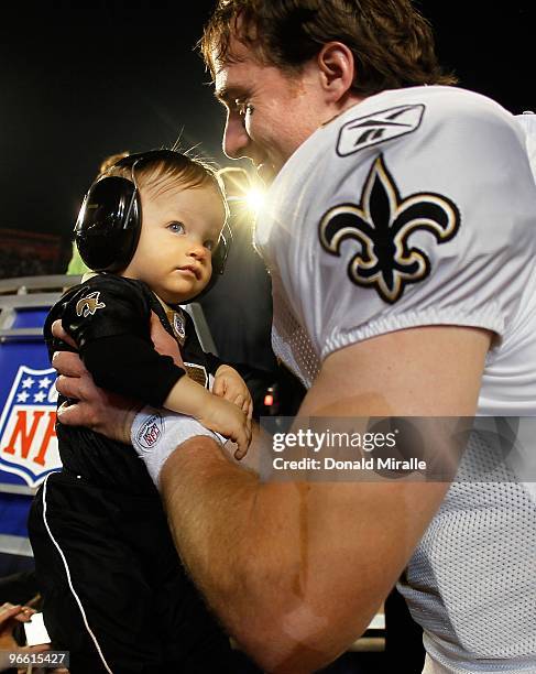 Drew Brees of the New Orleans Saints picks up his son Baylen Brees to celebrate after the Saints defeated the Indianapolis Colts during Super Bowl...