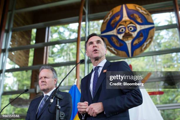 Bill Morneau, Canada's minister of finance, right, speaks as Stephen Poloz, governor of the Bank of Canada, listens during a news conference at the...