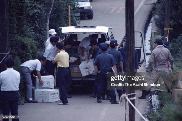 Police officers load boxes of collected soil from where suspect TSutomu Miyazaki confessed that he had burnt bones of killed girl on August 6, 1989...