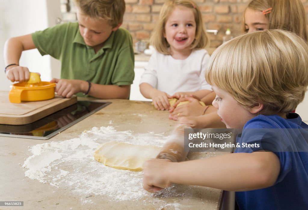 Four kids baking cookies