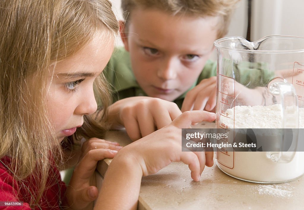 Girl and boy measuring flour