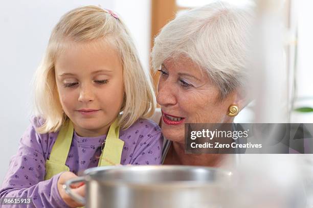 girl with grandmother cooking jam - jam making generations photos et images de collection