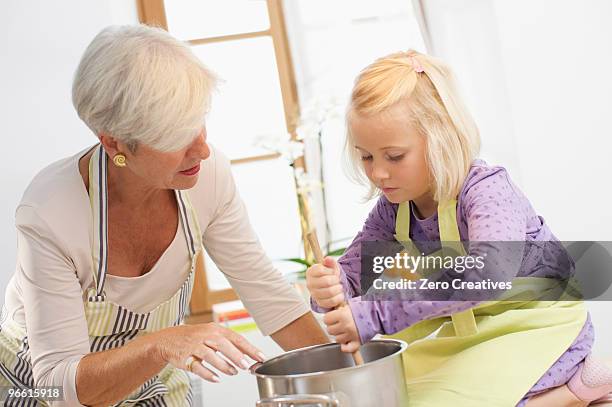 girl with grandmother cooking jam - jam making generations photos et images de collection