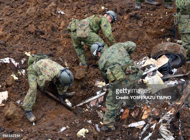 Sodats japonais effectuant des recherches pour retrouver des disparus après un tremblement de terre le 18 avril 2016, village de Minamiaso, Japon.