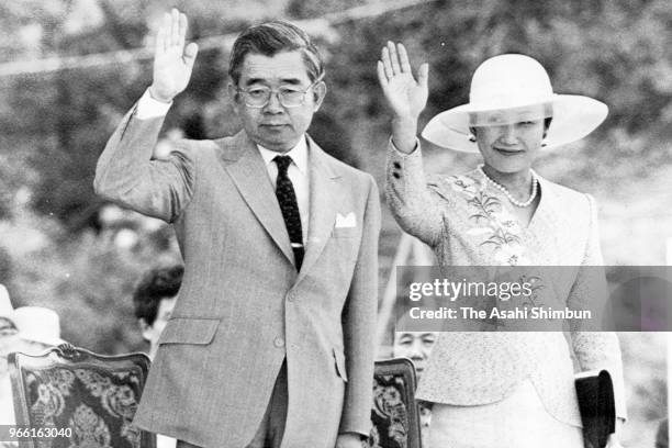 Prince Hitachi and Princess Hanako of Hitachi wave as they attend the Natural Parks Meeting at Shikanoshima Island on July 26, 1989 in Fukuoka, Japan.