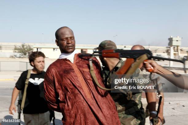 Combattants rebelles tenant en joue un prisonnier lors de l'attaque de Bab al-Azizia, caserne fortifiée, résidence de Mouammar Kadhafi, 23 aout 2011,...