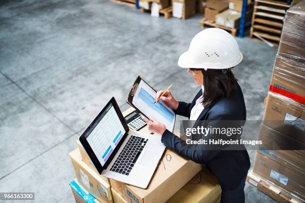 senior warehouse woman manager or supervisor with laptop. - belt over top - fotografias e filmes do acervo