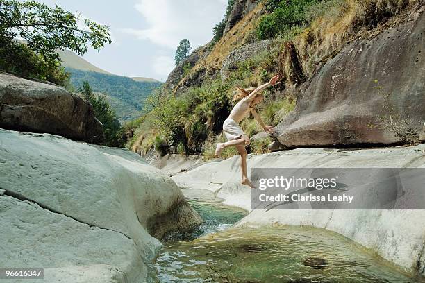 girl jumping over stream - kwazulu natal stock pictures, royalty-free photos & images