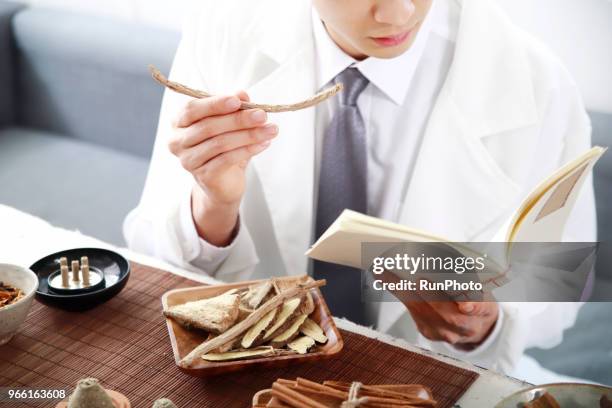 oriental medicine doctor reading book with herbal medicine - same person different looks stock-fotos und bilder