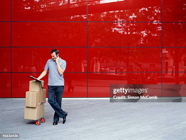 a courier delivers parcels - red telephone box photos et images de collection