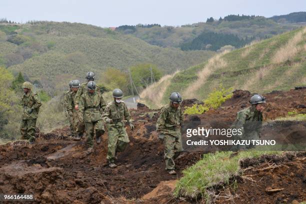 Sodats japonais effectuant des recherches pour retrouver des disparus après un tremblement de terre le 18 avril 2016, village de Minamiaso, Japon.