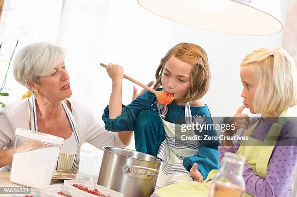 girls with grandmother cooking jam - jam making generations photos et images de collection