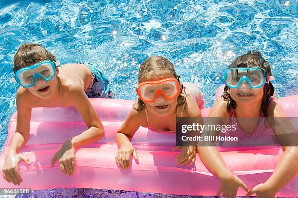 three kids on a inflatable in a pool - preteen girl no shirt stock pictures, royalty-free photos & images