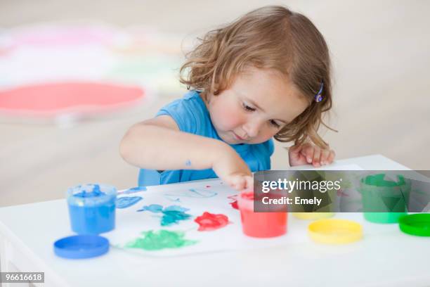 young girl playing with colours - finger painting stock pictures, royalty-free photos & images