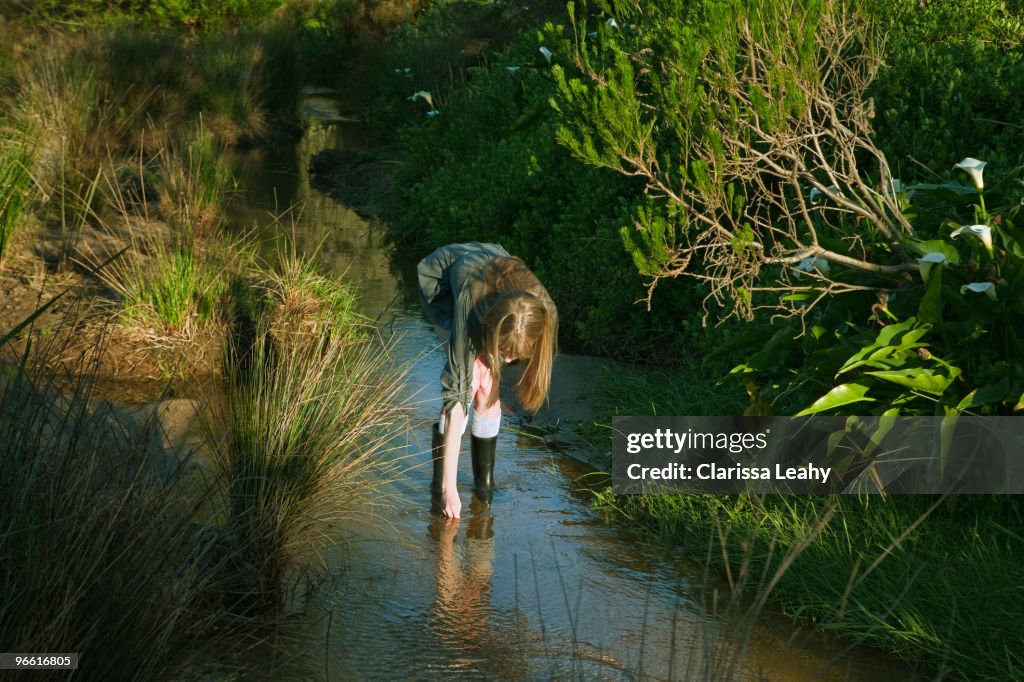 Girl bending down in stream