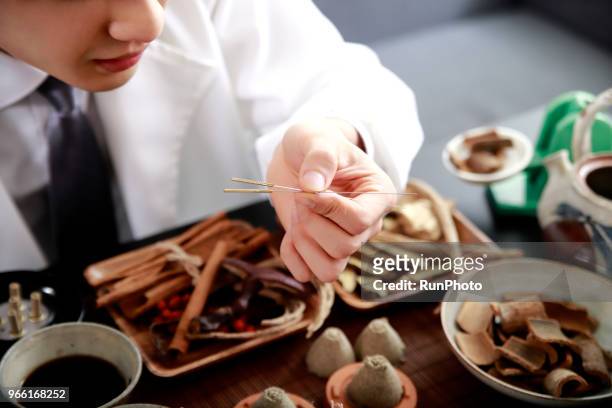doctor holding acupuncture needles - angelica hale stock pictures, royalty-free photos & images