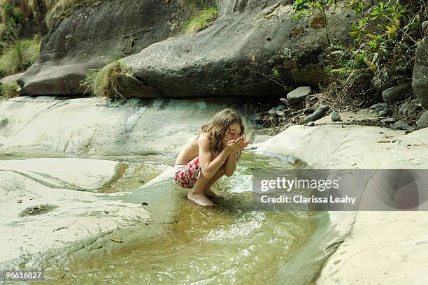 girl drinking water from stream - stream body of water fotografías e imágenes de stock