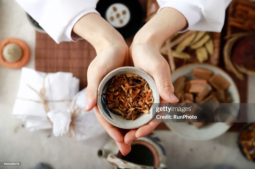 Doctor holding ball of dried herbal medicine