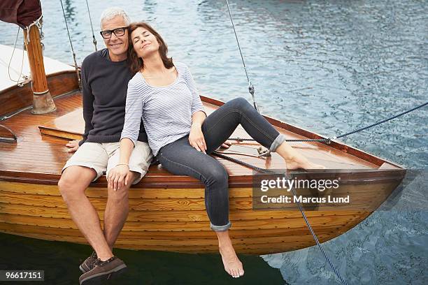 middle aged couple on old boat - couple voyage sport photos et images de collection