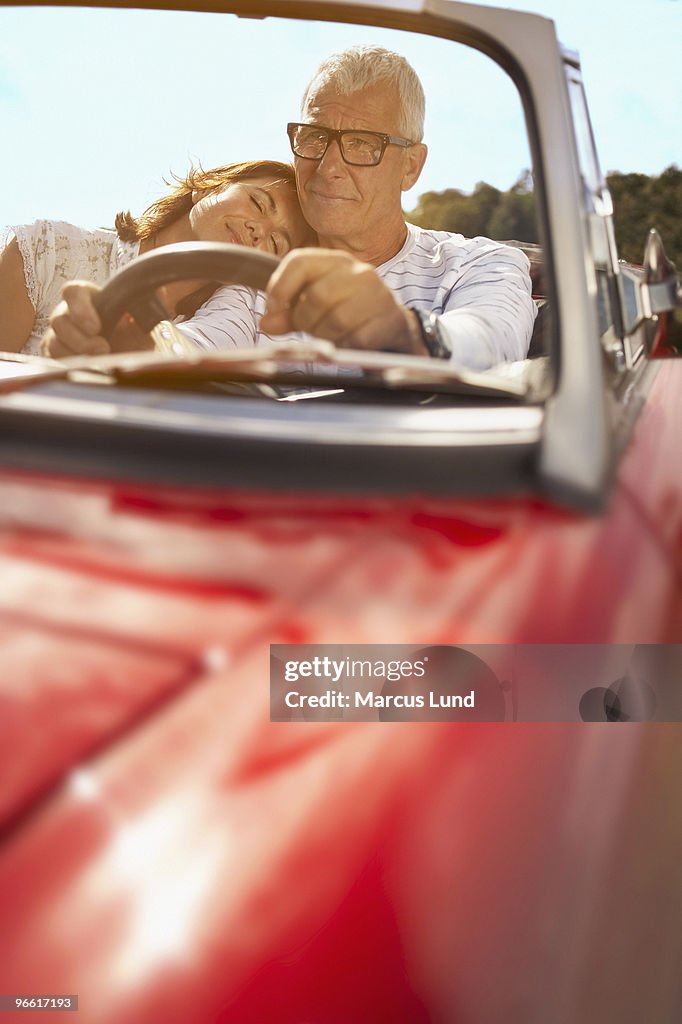 Couple in car, her head on shoulder